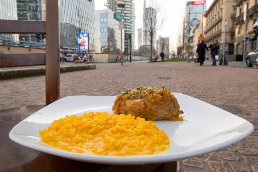 Ossobuco con risotto alla milanese servito all'esterno a Milano